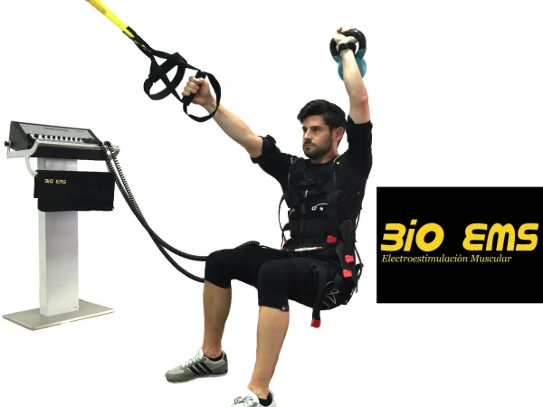 Hombre con traje de electroestimulación entrenando con TRX